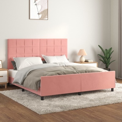 Cama rosa estofada com roupa de cama cinzenta e branca num quarto com tapete bege e mesa ao lado com candeeiro e planta