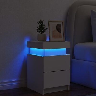 Móvel de apoio branco com gavetas e luz LED azul ao lado de cama cinza