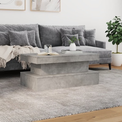 Mesa de centro moderna de concreto cinzento numa sala de estar com sofá cinzento e planta verde.