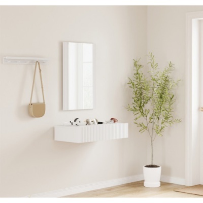 Sala com móvel suspenso branco, espelho, planta em vaso branco e cabide com bolsa bege