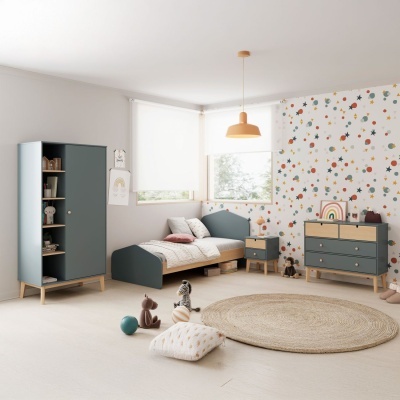 quarto infantil com móveis cinza azulado e creme, papel de parede colorido de estrelas, tapete redondo e brinquedos no chão