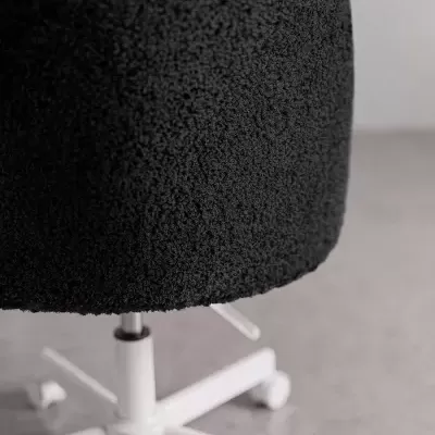 Cadeira de escritório preta com estofos em tecido boucle e base branca de rodas