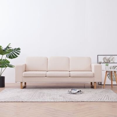 Sofá creme de três lugares com pés de madeira claro sobre tapete cinzento em sala minimalista