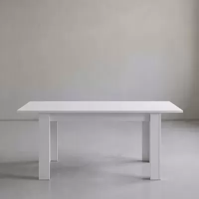 Mesa branca retangular com pernas quadradas grossas num espaço cinzento minimalista