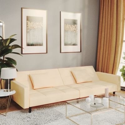 Sofá creme de três lugares numa sala moderna com decoração em tons neutros.