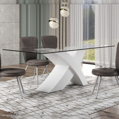 Mesa de jantar com tampo de vidro e base branca em sala com quatro cadeiras cinza e tapete geométrico