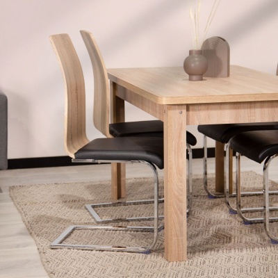 Mesa de madeira clara com quatro cadeiras pretas acolchoadas e pés de metal sobre tapete bege em sala