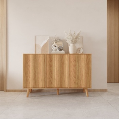 Aparador de madeira clara com decoração minimalista em cima contra parede branca