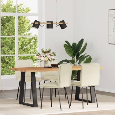 Mesa de madeira clara com pés pretos e quatro cadeiras bege ao redor, decoração com flores e planta verde em ambiente interior claro.