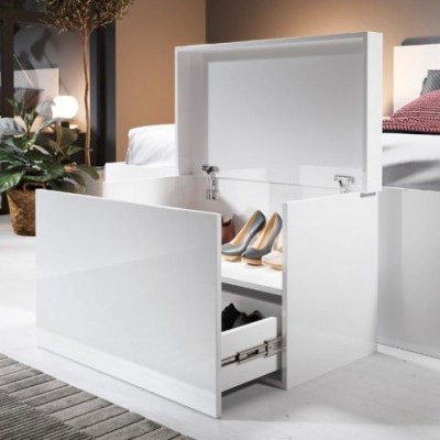 Cubo de arrumação branco lacado aberto com sapatos dentro ao lado de uma cama