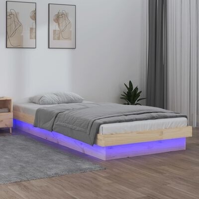 Cama de solteiro com base iluminada por luz LED azul e roupa de cama cinza em quarto minimalista