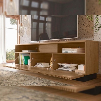 Móvel TV em madeira clara com prateleiras e porta deslizante, com livros e objetos decorativos