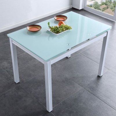 Mesa de vidro fosco azul claro com estrutura branca e decoração de frutas e taças