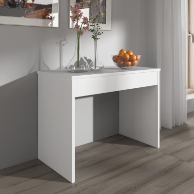 Mesa branca simples com vaso de flores e tigela de laranjas junto a janela com cortinas brancas