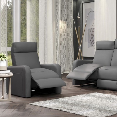 Duas poltronas reclináveis de couro cinza num ambiente moderno com cortinas brancas e piso de madeira.