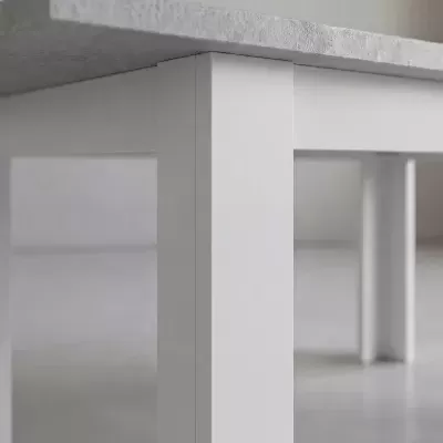 Mesa cinza claro com pernas brancas retas em ambiente minimalista