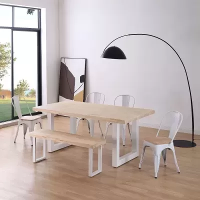 Mesa de jantar em madeira clara, banco e cadeiras metálicas brancas com assento em madeira, candeeiro de chão preto e quadro abstrato