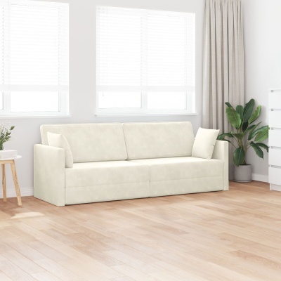 Sofá branco creme de três lugares numa sala com chão de madeira clara, janelas com estores brancos, plantas e cómoda branca