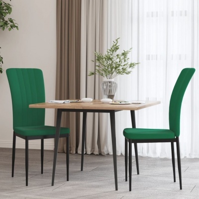 Mesa de madeira clara com duas cadeiras verdes em ambiente interior com cortinas e vaso de vidro