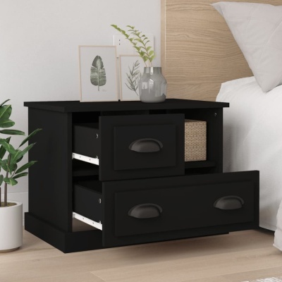 Mesa de cabeceira preta com gavetões e decoração de folhas ao lado de cama