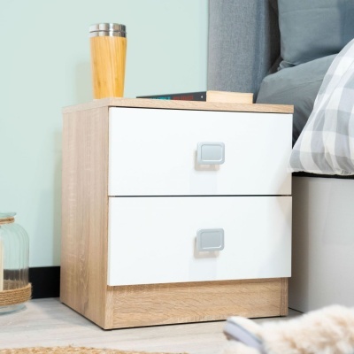 Mesa de cabeceira com duas gavetas brancas e corpo madeira clara ao lado de cama com almofada cinza