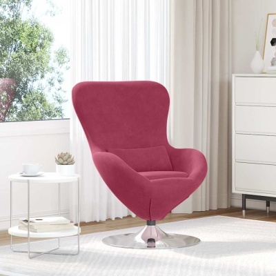 Cadeira de descanso rosa com base metálica redonda prateada numa sala clara com mesa branca arredondada