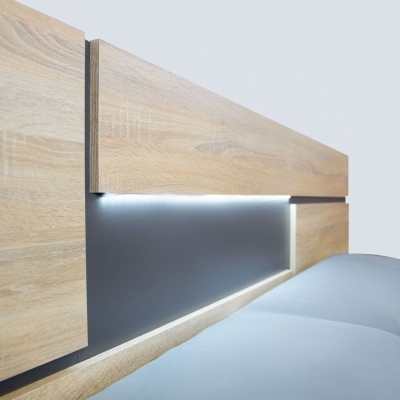 Cabeceira de cama em madeira clara com painel cinzento e iluminação LED embutida