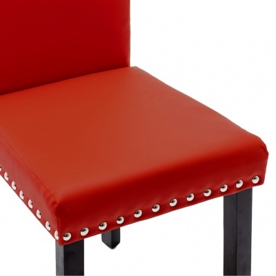 cadeira vermelha com pernas pretas e tachas metálicas
