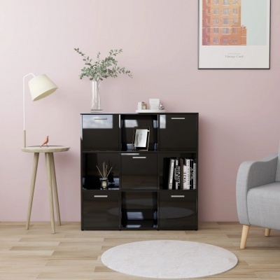 Móvel preto de arrumação com nove compartimentos numa sala com parede rosa, mesa de apoio com candeeiro e planta, tapete branco redondo no chão e quadro pendurado na parede.