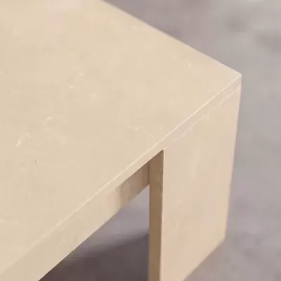 Mesa de pedra bege com acabamento liso sobre fundo cinzento