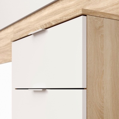 Móvel de madeira clara com gavetas brancas e puxadores metálicos