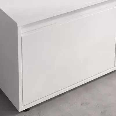Móvel de arrumação branco com porta simples sobre chão cinzento