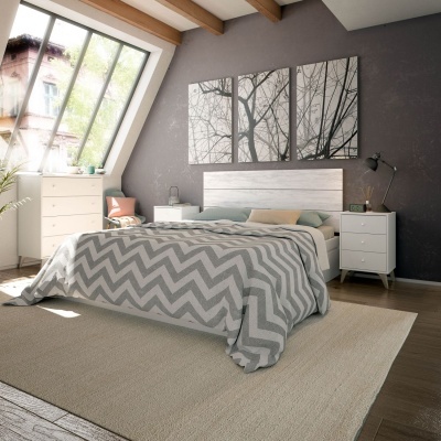 Quarto moderno com cama de madeira clara, roupa de cama cinza e branca, móveis brancos e quadros de árvores na parede cinzenta.