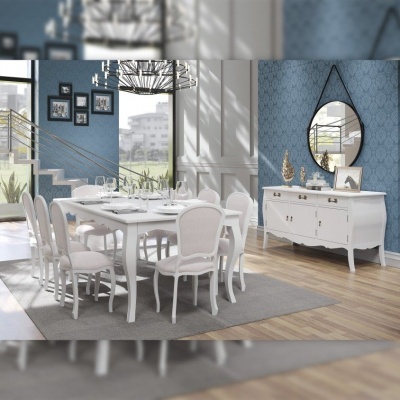 Sala de jantar mobiliada com mesa branca, cadeiras estofadas, aparador branco e espelho redondo na parede azul.