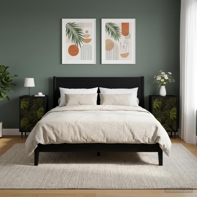 Quarto com cama de madeira preta, roupa de cama bege, mesas de cabeceira pretas com padrão verde, abajur branco, vaso com flores, paredes verdes e quadros abstratos.