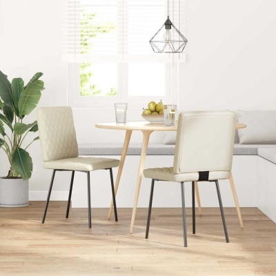 Duas cadeiras de pele sintética bege com pernas metálicas e madeira numa sala luminosa com mesa redonda e planta