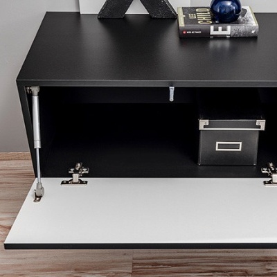 Móvel de madeira preto com porta branca aberta e objetos em cima