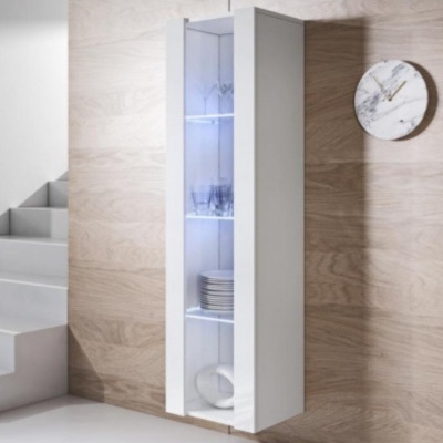 Móvel branco vertical iluminado com prateleiras de vidro, copos, pratos e panela, montado em parede de madeira clara junto a escada e relógio de parede