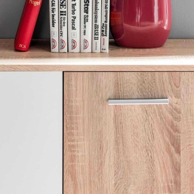 Estante de madeira clara com livros e vaso vermelho