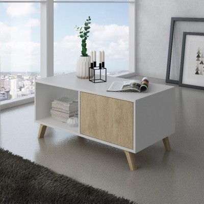 Mesa de centro branca e castanha clara, com objetos decorativos, numa sala interior com janelas grandes