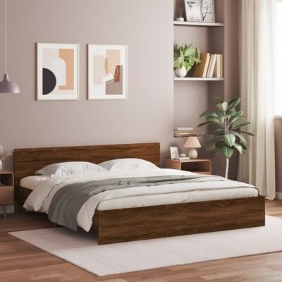 Quarto moderno com cama de madeira castanha, roupa de cama branca e cinza, mesas de cabeceira, plantas e decoração na parede.