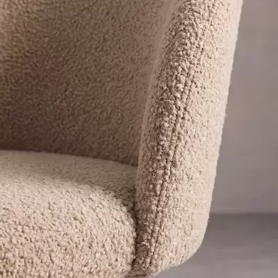 Cadeira estofada com tecido bouclé bege e costuras detalhadas