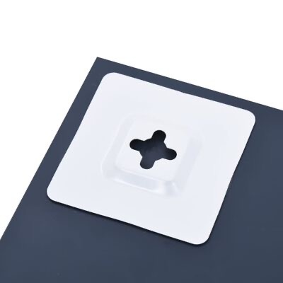 Adesivo branco com recorte em forma de cruz numa superfície escura