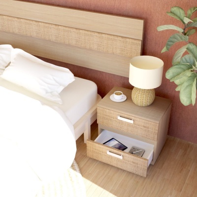 Mesa de cabeceira de madeira clara com lâmpada e chávena ao lado de cama