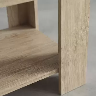 Móvel de madeira clara com textura visível sobre chão cinzento
