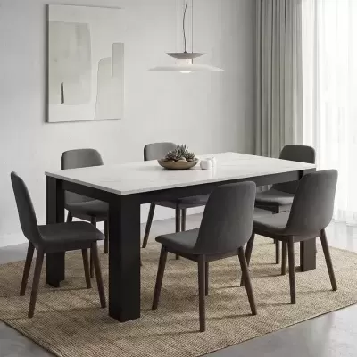 Sala de jantar com mesa branca, cadeiras cinzentas, tapete natural e lâmpada pendente