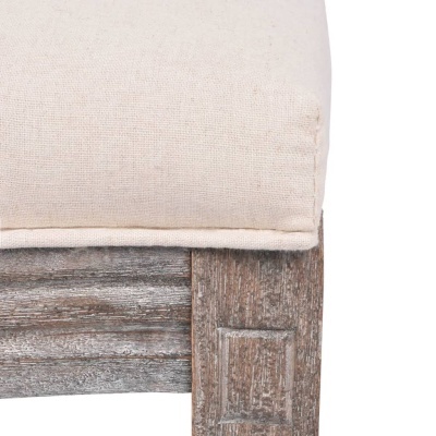 Almofada bege em móvel de madeira envelhecida com detalhes entalhados