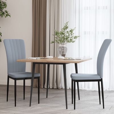 mesa de jantar com duas cadeiras estofadas cinza-azul e vaso com plantas