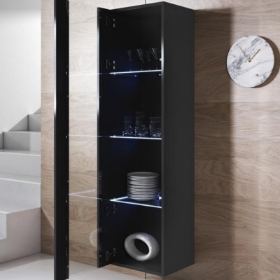 Armário vertical preto com porta de vidro aberta e objetos internos, montado numa parede de madeira ao lado de escada e relógio redondo Mármore