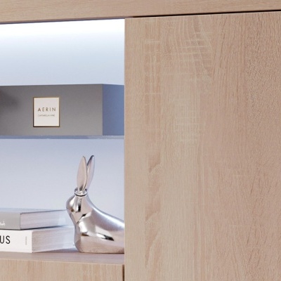 Caixa AERIN, figura de coelho metálica, livros numa prateleira de madeira clara